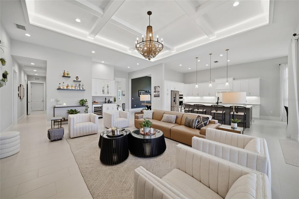 A covered outdoor patio features a pool, lounge seating, dining area, and wood-paneled ceiling — 8254 PAVIA WAY, LAKEWOOD RANCH, FL