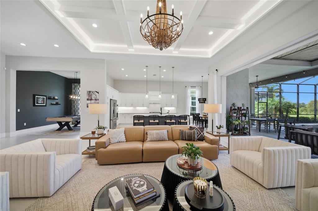 A bright bedroom features a white bed, two nightstands, and glass doors leading to a patio — 8254 PAVIA WAY, LAKEWOOD RANCH, FL