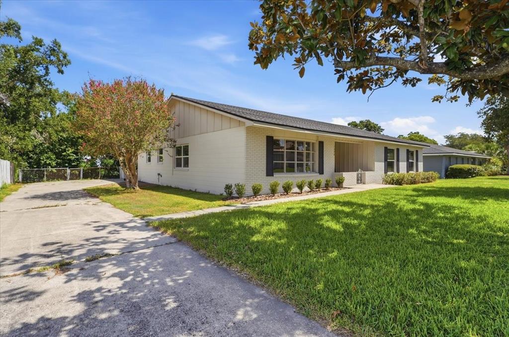 A white brick house with a concrete driveway and a large front lawn — 1308 GLENFORD LANE, LAKELAND, FL