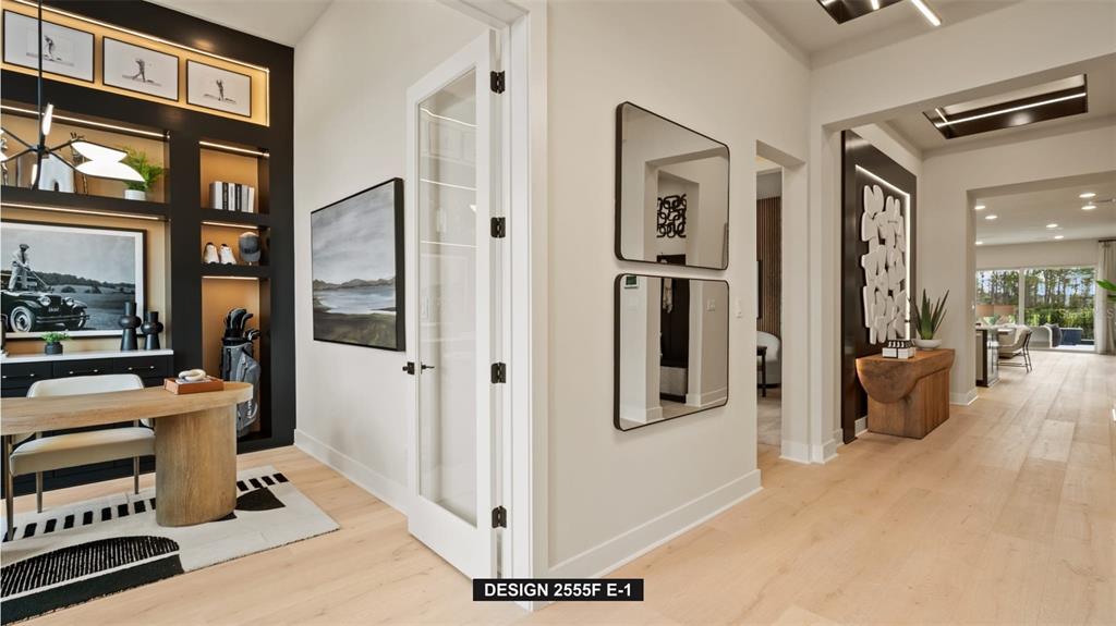 A modern home interior features a study with built-in shelving, glass doors, and hardwood floors — 9515 SANDY SHORES STREET, PARRISH, FL