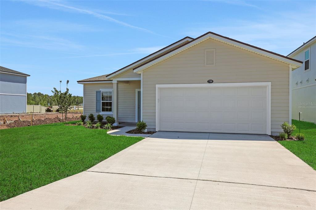 A bright entryway features a white front door with sidelights, wood-look flooring, and high ceilings — 5700 LAGOON CRUISE WAY, JACKSONVILLE, FL