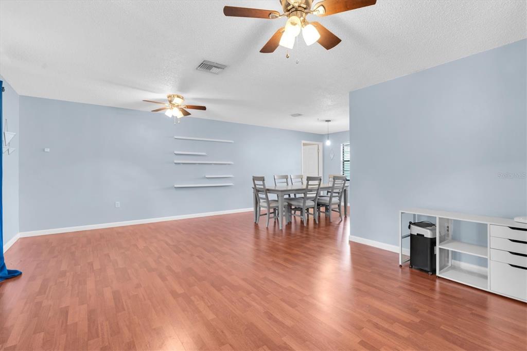 A dining area with a table and chairs sits in a room with light blue walls — 914 HARBOR CIRCLE, PALM HARBOR, FL