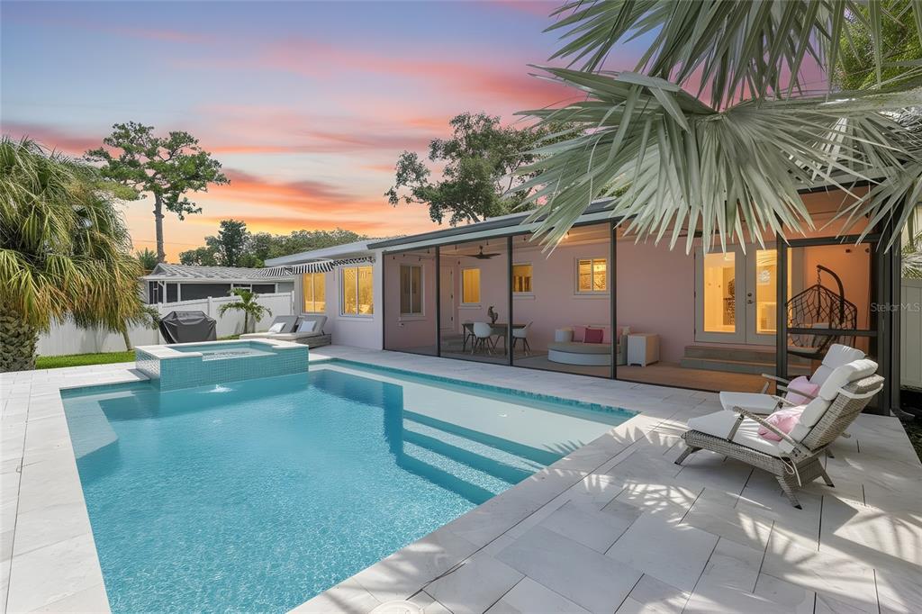 A backyard features a swimming pool with a hot tub, patio furniture, and a screened-in porch — 223 PINECREST DRIVE, PALM HARBOR, FL