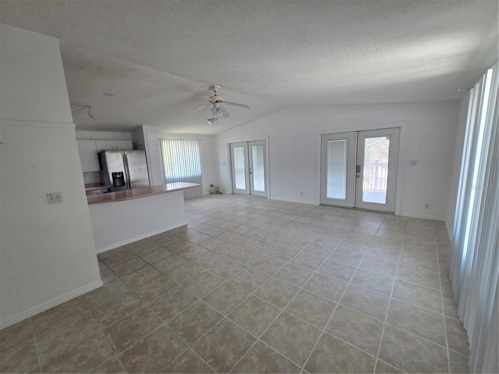 A living room features a floral sectional sofa, a wooden coffee table, and a recliner — 2804 AVENUE C, HOLMES BEACH, FL