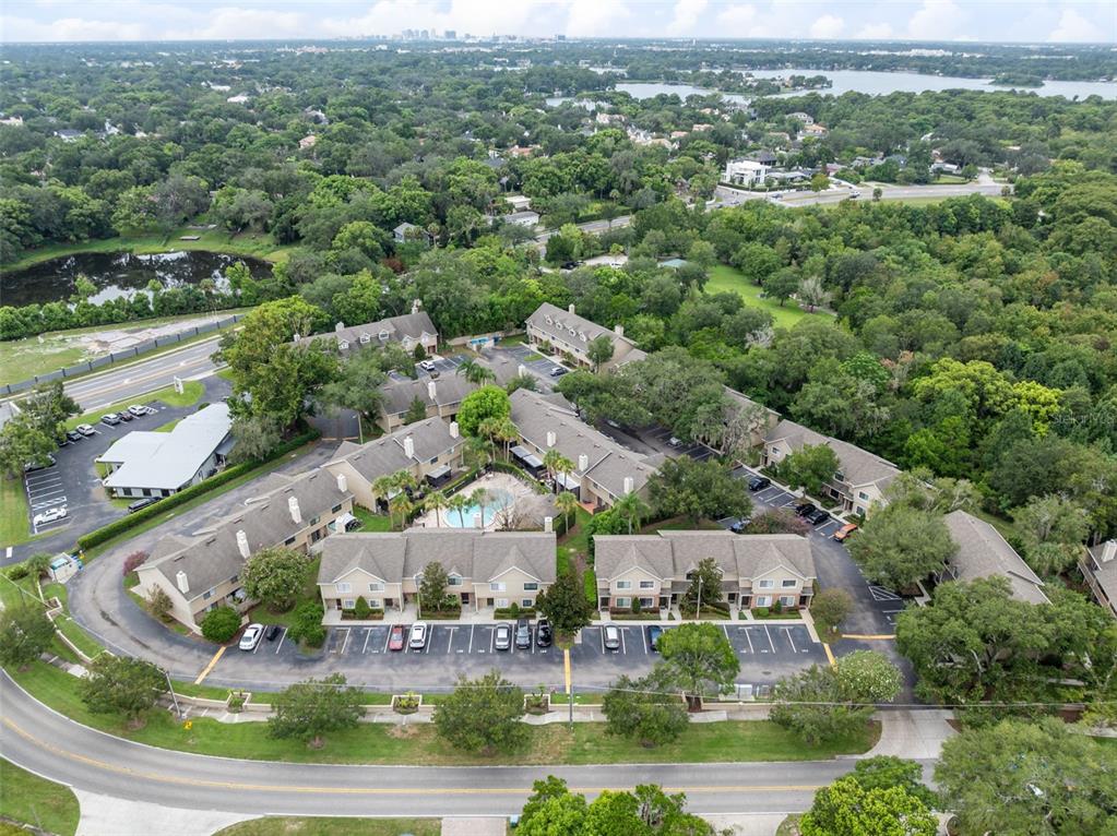 An aerial view shows a multi-building apartment complex with a central pool and parking lots — 283 SANDLEWOOD TRAIL UNIT 3, WINTER PARK, FL