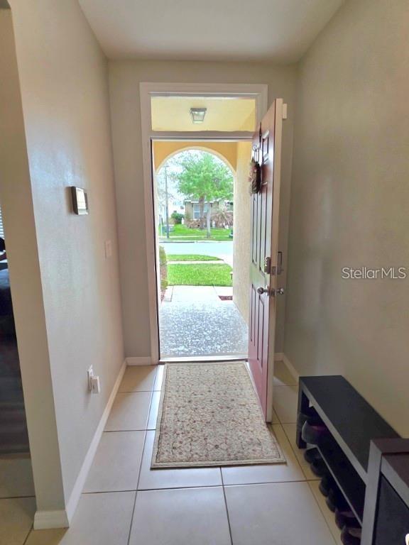 An entryway features light-colored tile flooring, a beige rug, and an open front door — 368 ABERDEEN DRIVE, DAVENPORT, FL