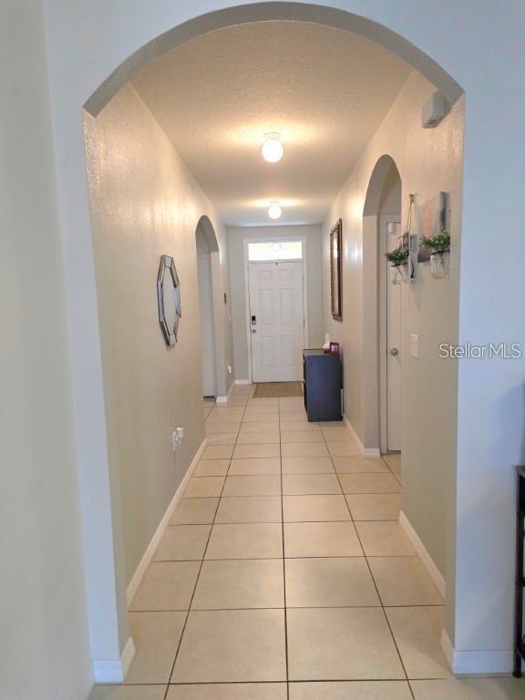 A tiled hallway features an arched entryway, two ceiling lights, and a white front door — 368 ABERDEEN DRIVE, DAVENPORT, FL