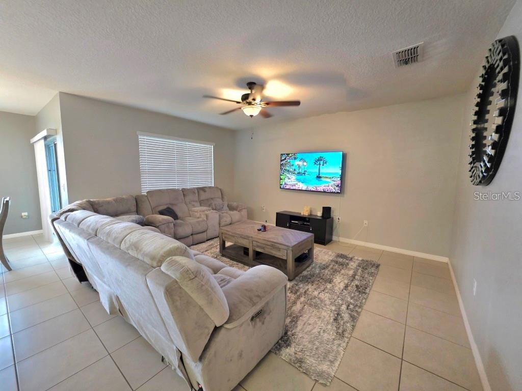 A living room features a large gray sectional sofa, a coffee table, and a wall-mounted television — 368 ABERDEEN DRIVE, DAVENPORT, FL