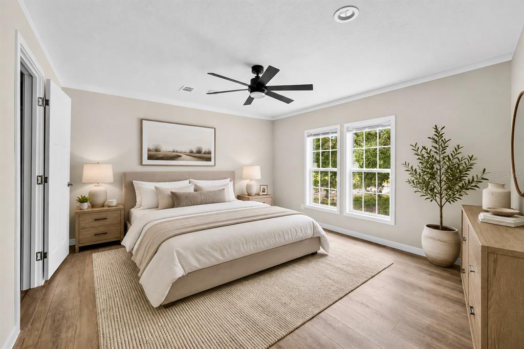 A bedroom features a bed with neutral bedding, a ceiling fan, and light wood flooring — 16918 NW 264TH STREET, OKEECHOBEE, FL