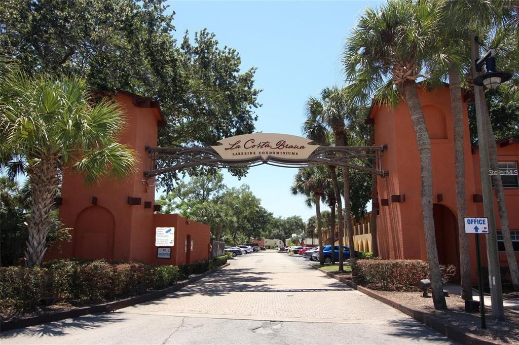 A swimming pool with lounge chairs sits in front of a multi-story apartment building — 772 E MICHIGAN STREET UNIT 70, ORLANDO, FL