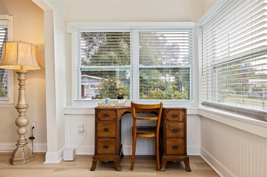 A wooden desk and chair sit in front of windows in a room with light flooring — 1601 54TH STREET S, GULFPORT, FL