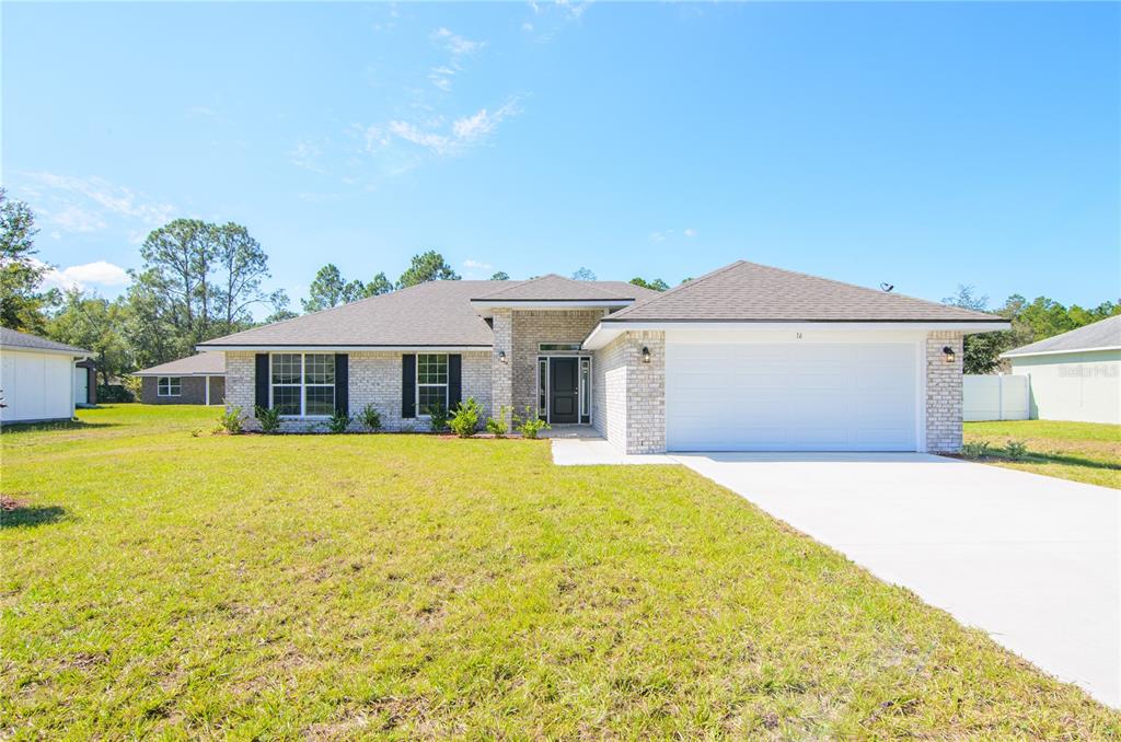 A single-story brick house with a two-car garage and a concrete driveway — 57 RADCLIFFE DRIVE, PALM COAST, FL