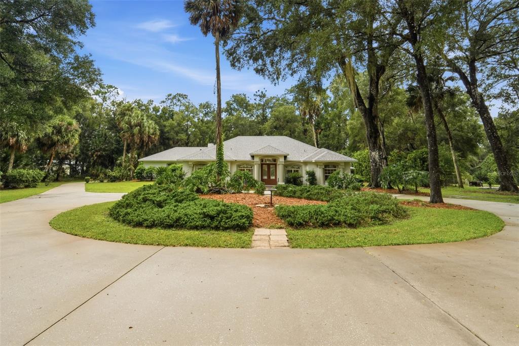 A single-story house with a circular driveway and a landscaped island in the front yard — 1830 GLENWOOD OAKS LANE, DELAND, FL
