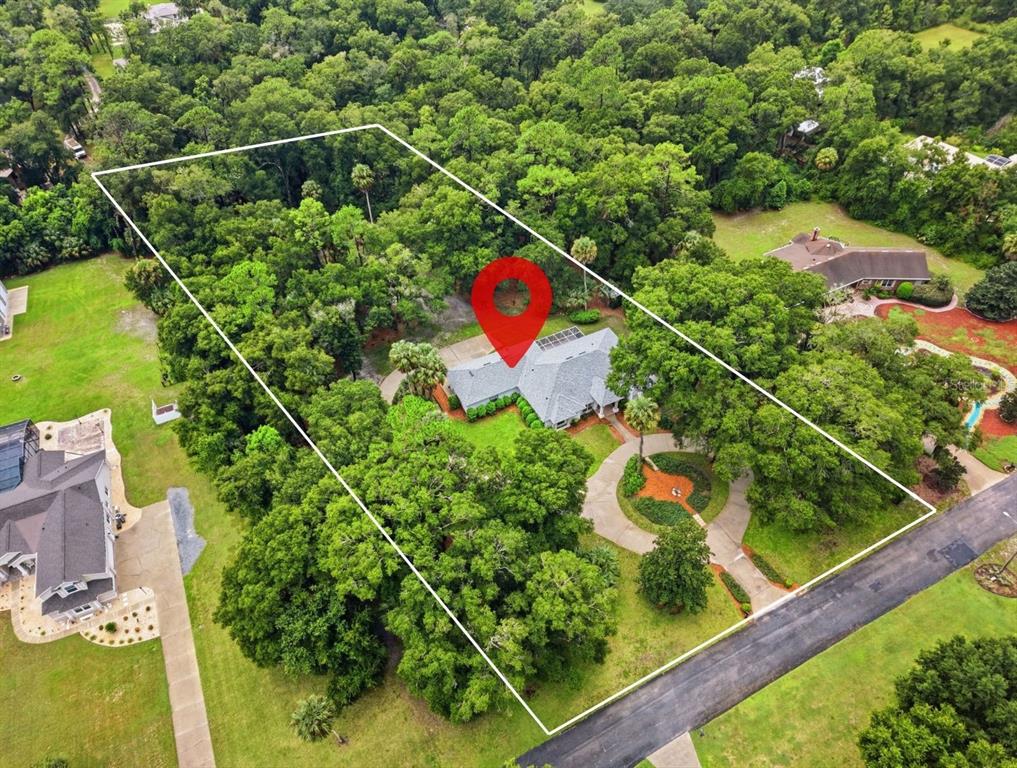 An aerial view shows a house with a circular driveway surrounded by dense trees — 1830 GLENWOOD OAKS LANE, DELAND, FL