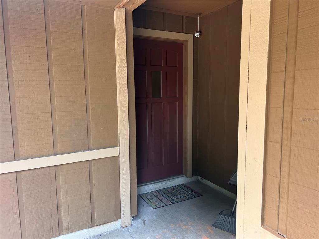 A brown front door is set within a recessed entryway with wood-paneled exterior walls — 2919 NICHOLAS ROAD, FORT PIERCE, FL