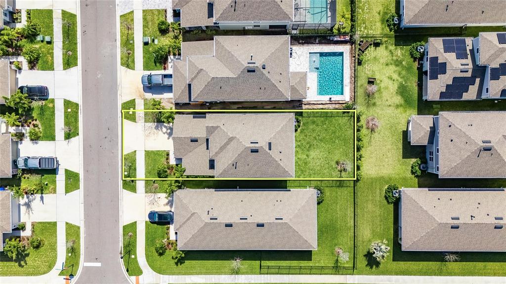 An aerial view shows a residential house with a fenced backyard and a concrete driveway — 6255 GOLDEN BEACH DRIVE, APOLLO BEACH, FL