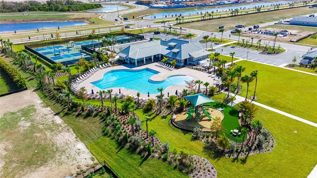 An aerial view shows a community clubhouse with a swimming pool, tennis courts, and playground — 6255 GOLDEN BEACH DRIVE, APOLLO BEACH, FL