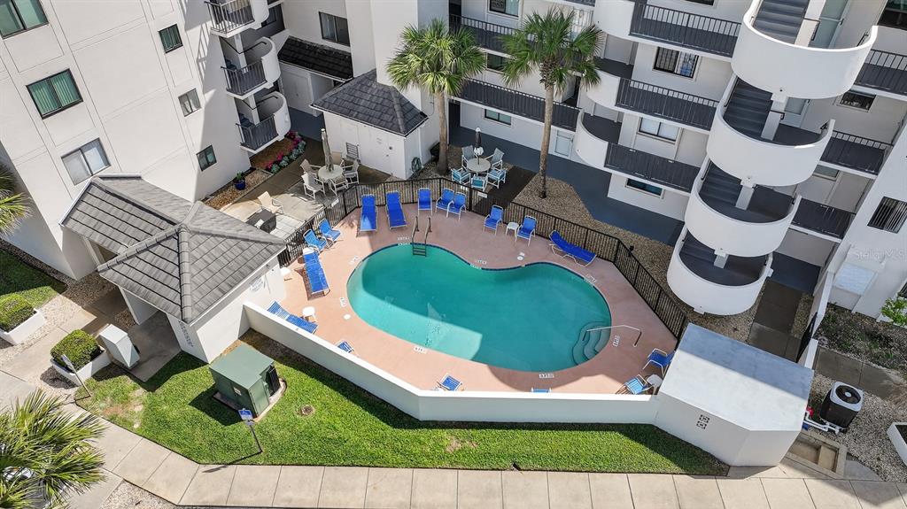 An aerial view of an apartment complex courtyard featuring a swimming pool and lounge chairs — 2860 OCEAN SHORE BOULEVARD UNIT 2060, ORMOND BEACH, FL