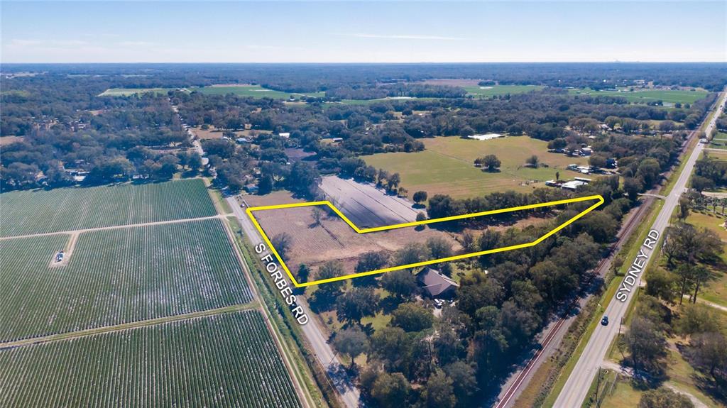 This is an aerial view of a vacant lot outlined in yellow between two roads — S. FORBES ROAD, DOVER, FL