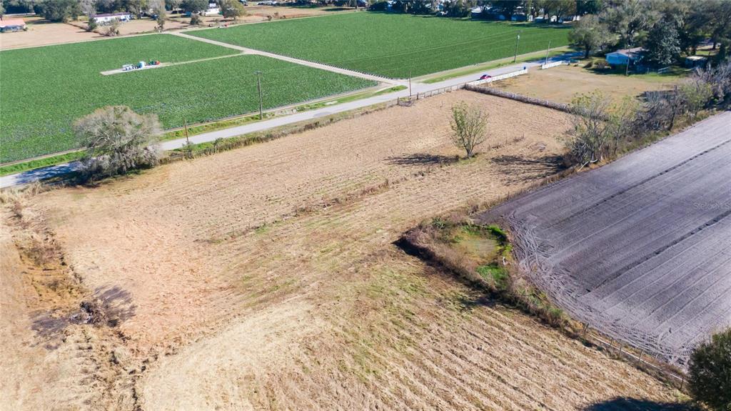 An aerial view shows a large, mostly cleared plot of land adjacent to a paved road — S. FORBES ROAD, DOVER, FL