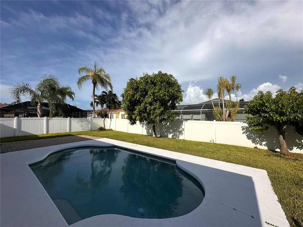 A backyard features a swimming pool, a grassy lawn, and a white privacy fence — 5010 44TH STREET W, BRADENTON, FL