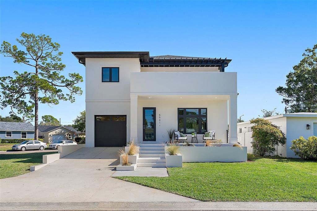 A modern two-story white stucco house features a flat roof, dark accents, and front porch — 5941 MANGROVE STREET N, ST PETERSBURG, FL