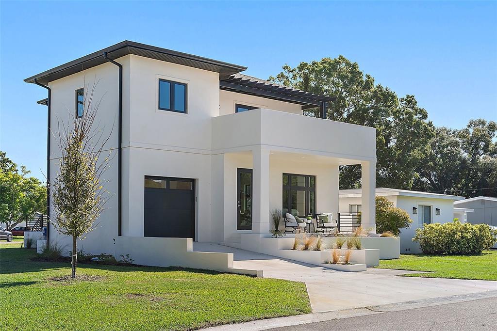 A modern two-story white house with a flat roof, dark window frames, and a front porch — 5941 MANGROVE STREET N, ST PETERSBURG, FL