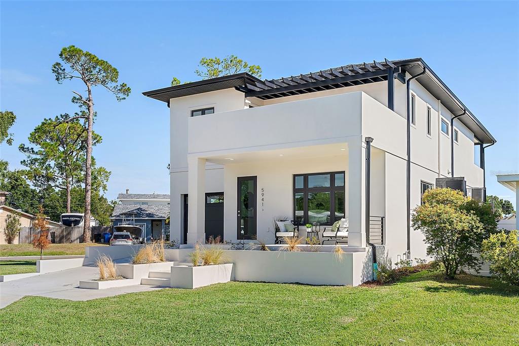 A modern two-story house with white stucco walls, a flat roof, and a front porch — 5941 MANGROVE STREET N, ST PETERSBURG, FL