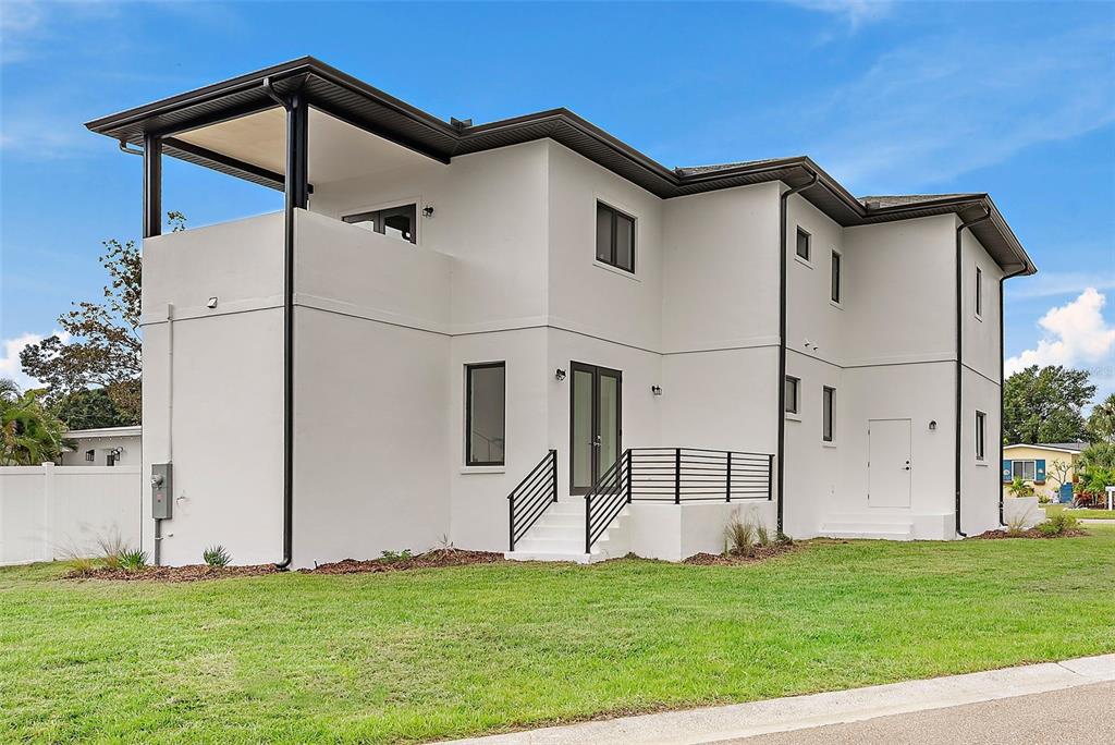 A two-story white stucco house with a covered balcony and black metal railings — 5941 MANGROVE STREET N, ST PETERSBURG, FL