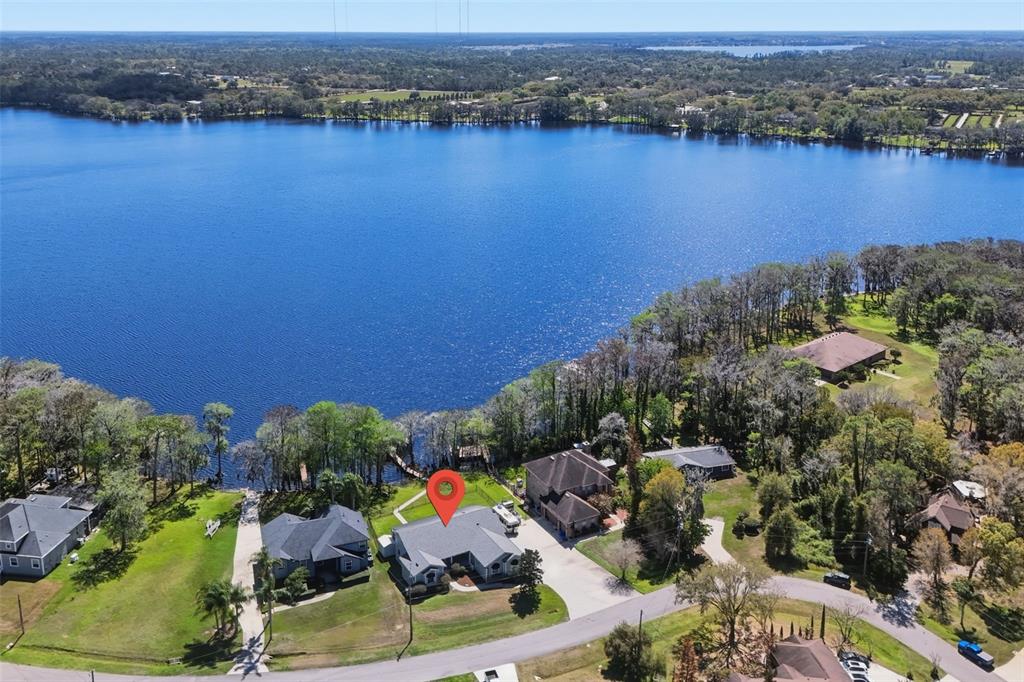An aerial view shows a house with a red location pin beside a lake — 834 MILLSHORE DRIVE, CHULUOTA, FL