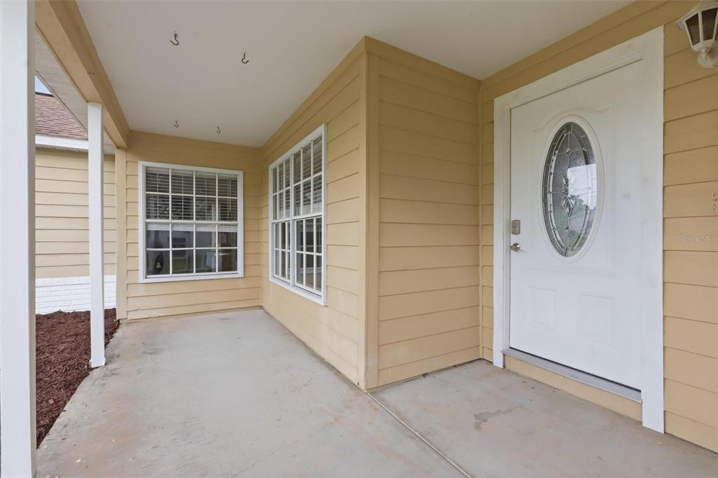 A single-story house with yellow siding, a two-car garage, and a front porch — 2695 KEENE LANE, DELTONA, FL