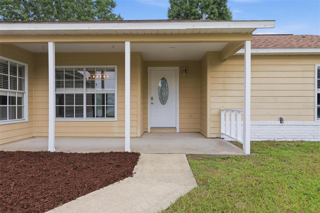 A single-story yellow house with a brown roof, a palm tree, and a front lawn — 2695 KEENE LANE, DELTONA, FL