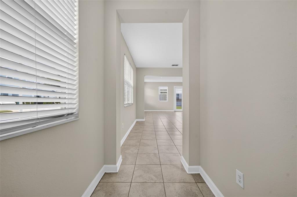 A two-story light green townhouse with a single-car garage and a paved driveway — 2900 TITLE STREET, KISSIMMEE, FL