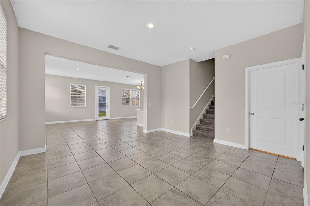 The exterior of a light green two-story townhouse features a small patio and landscaping — 2900 TITLE STREET, KISSIMMEE, FL