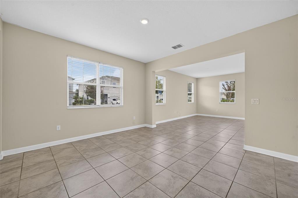 A hallway with tile flooring leads to an open living area with a glass door — 2900 TITLE STREET, KISSIMMEE, FL