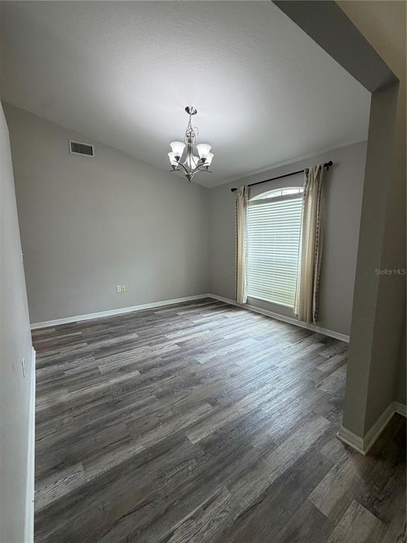 A kitchen features light-colored cabinets, stainless steel appliances, and wood-look flooring — 5619 FISCHER DRIVE, LAKELAND, FL