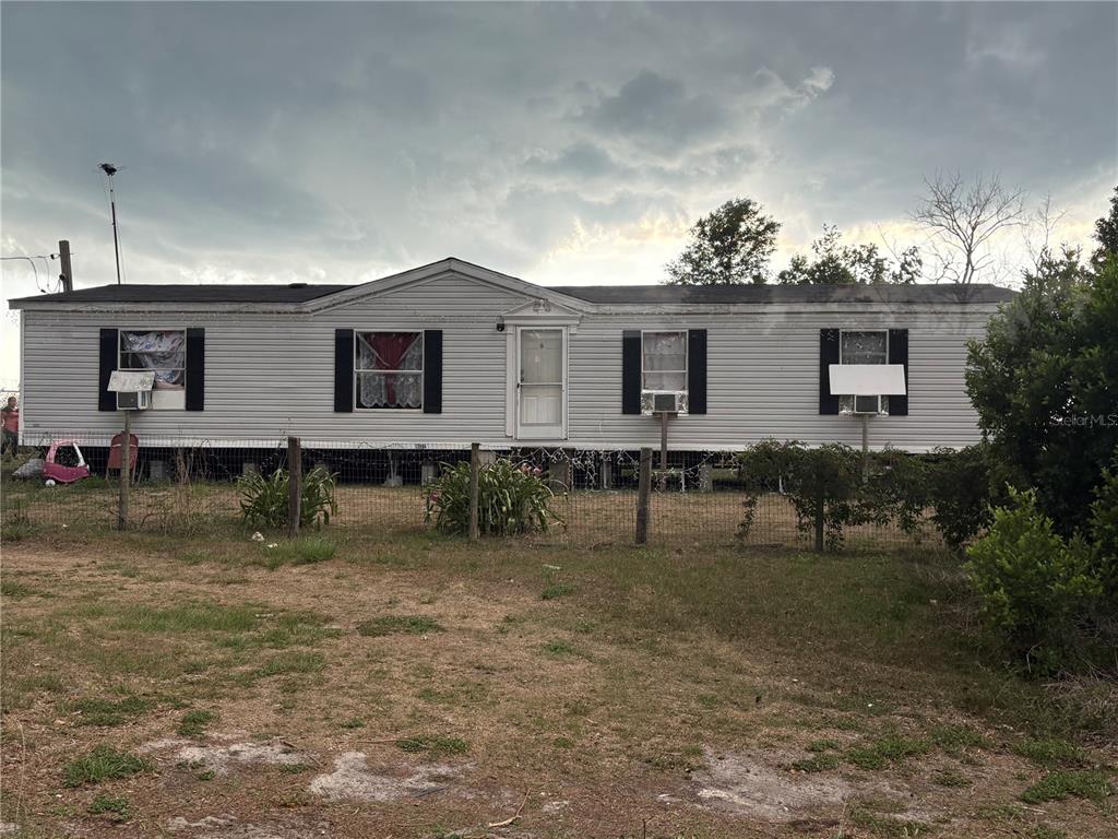 A metal gate opens to a large, grassy pasture with grazing cattle under a cloudy sky — 13994 COUNTY ROAD 209, OXFORD, FL