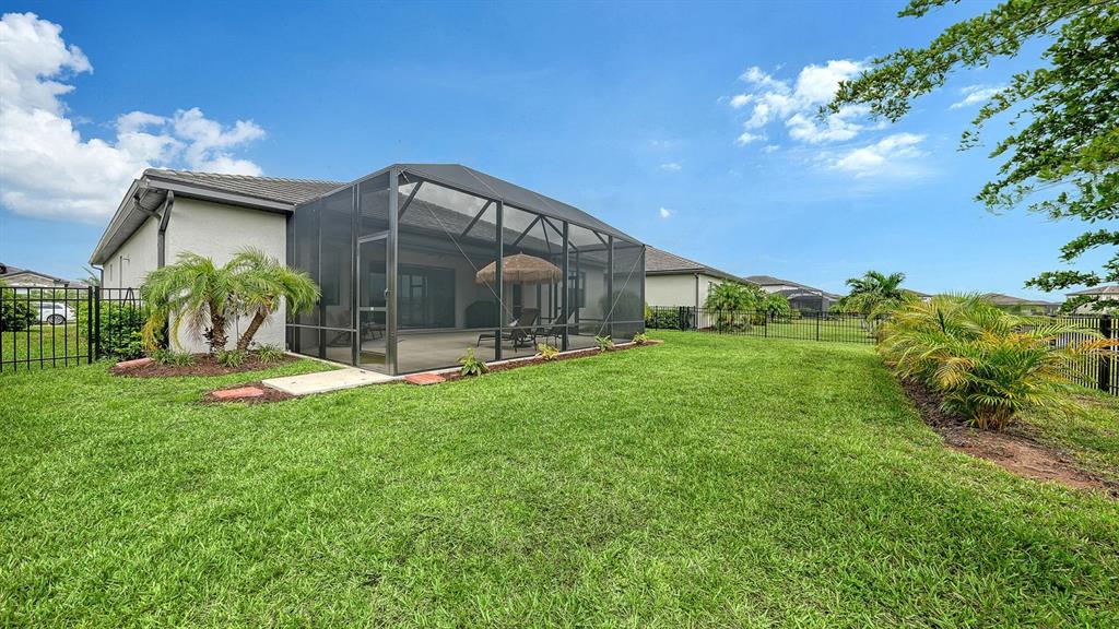 A kitchen features white cabinetry, stainless steel appliances, a marble-topped island, and tile flooring — 4971 OYSTER PEARL STREET, BRADENTON, FL