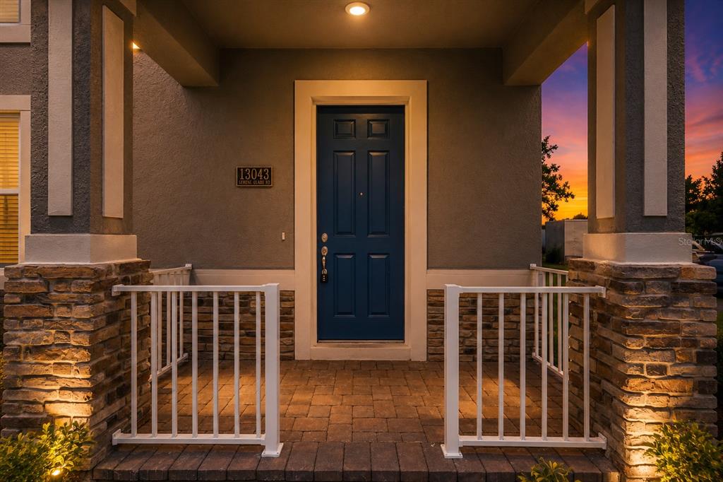 An open-concept living room, dining area, and kitchen with white cabinetry and neutral furnishings — 13043 SERENE GLADE ROAD, WINTER GARDEN, FL