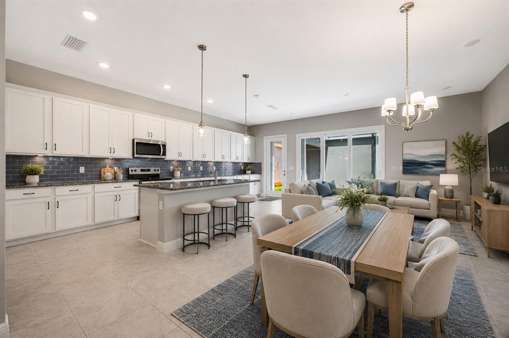A bedroom features a king bed, a bench, two nightstands, and windows with neutral curtains — 13043 SERENE GLADE ROAD, WINTER GARDEN, FL