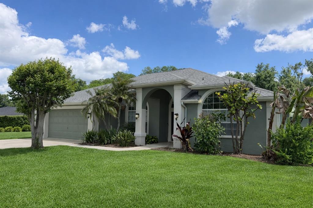A single-story house with a gray exterior, a two-car garage, and a covered front entryway — 1616 KINSMERE DRIVE, TRINITY, FL