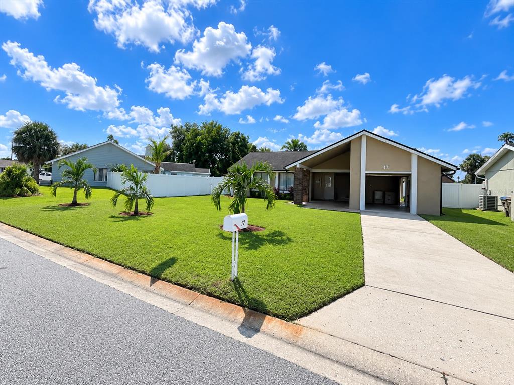 A backyard features a green lawn, a white vinyl fence, and an above-ground pool — 17 S FLAG DRIVE, KISSIMMEE, FL