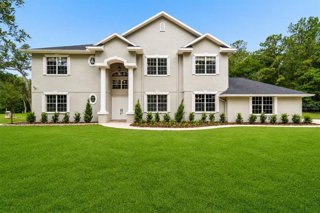 An aerial view of a suburban house with a pool cage surrounded by dense forest — 18326 SUCCESS ROAD, BROOKSVILLE, FL