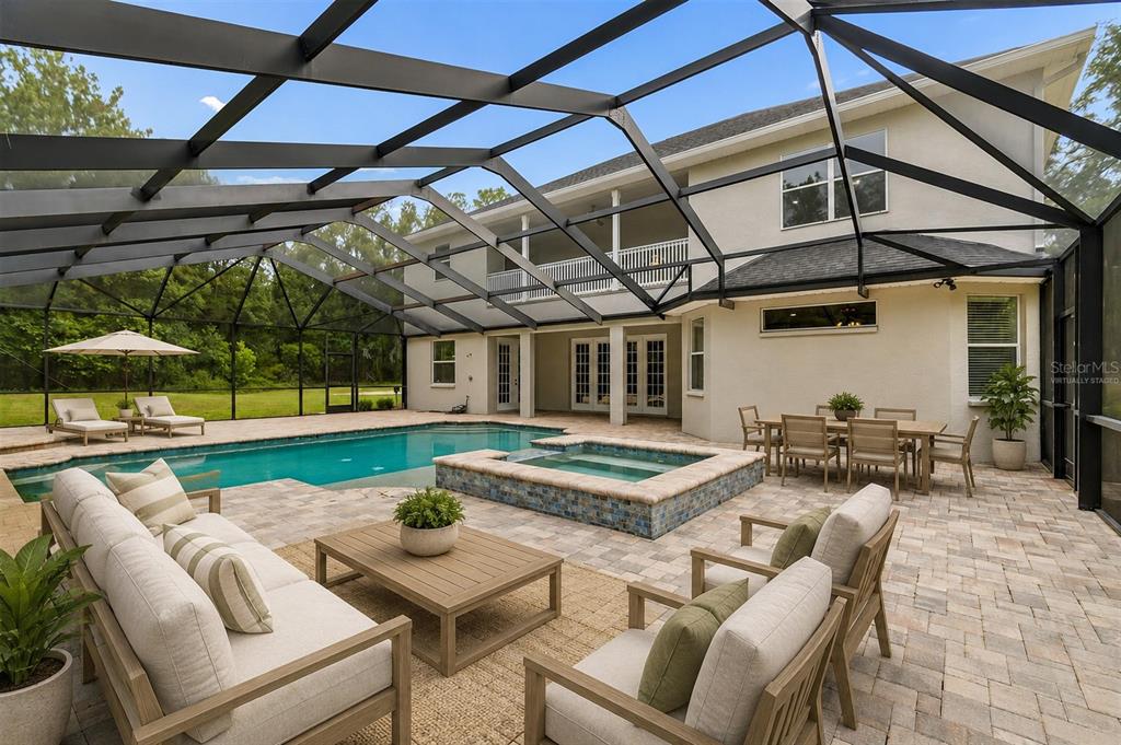 A screened-in patio features a swimming pool, a raised spa, and outdoor furniture — 18326 SUCCESS ROAD, BROOKSVILLE, FL