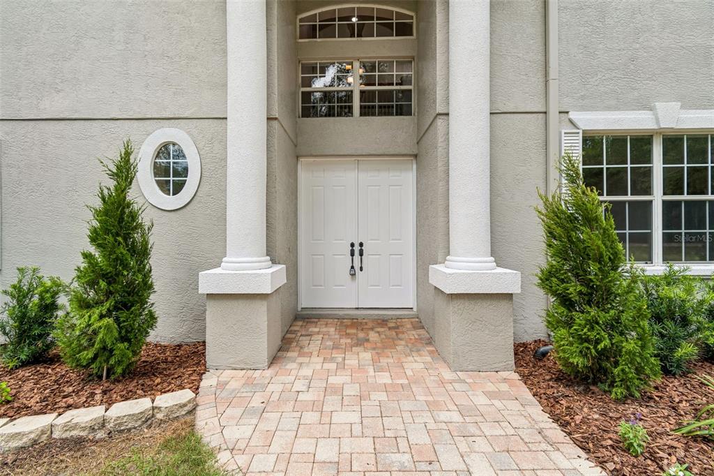 The exterior entrance features double white doors, two large columns, and a brick walkway — 18326 SUCCESS ROAD, BROOKSVILLE, FL