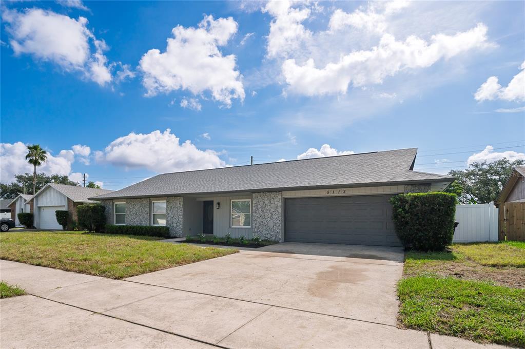 A single-story house with a gray garage, stone facade, and a concrete driveway — 5112 JEANNINE COURT, ORLANDO, FL