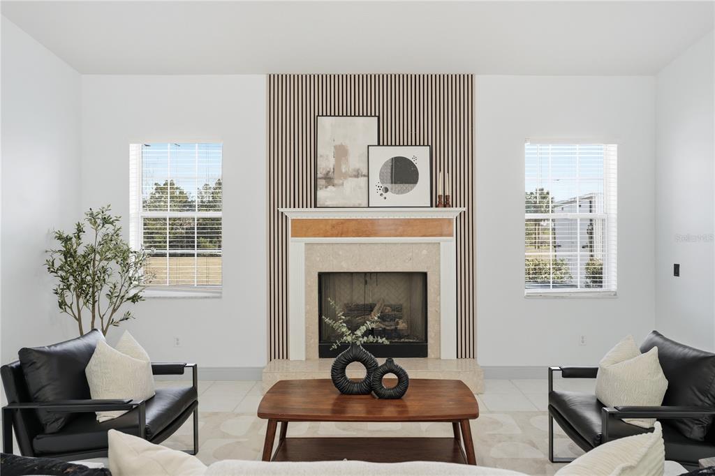 A living room features a fireplace with a wood mantel and vertical slat wall paneling — 4873 NE 64 AVENUE, SILVER SPRINGS, FL
