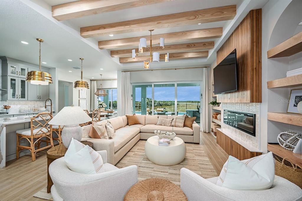 A living room features wood ceiling beams, a fireplace, and a large sectional sofa — 17524 MACARTHUR LOOP, VENICE, FL