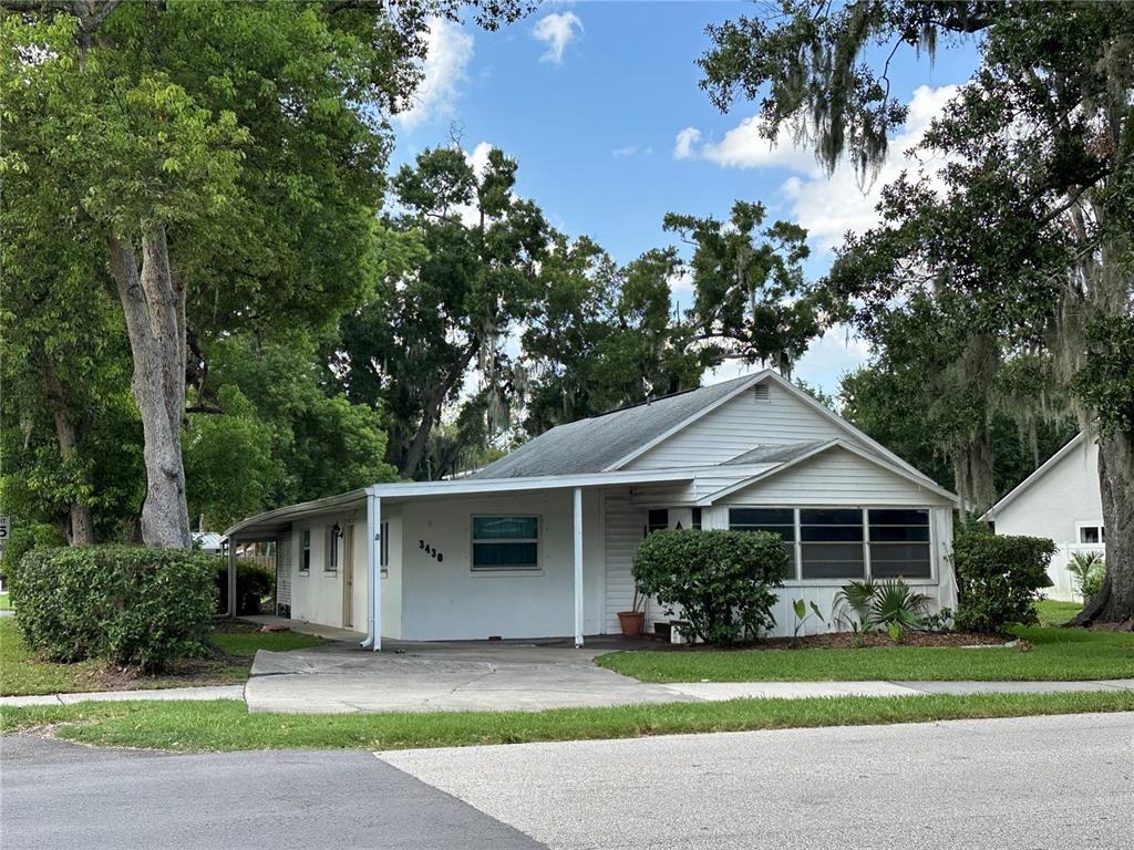 A white single-story house with a covered carport and a grassy front yard — 3430 5TH STREET, ST CLOUD, FL