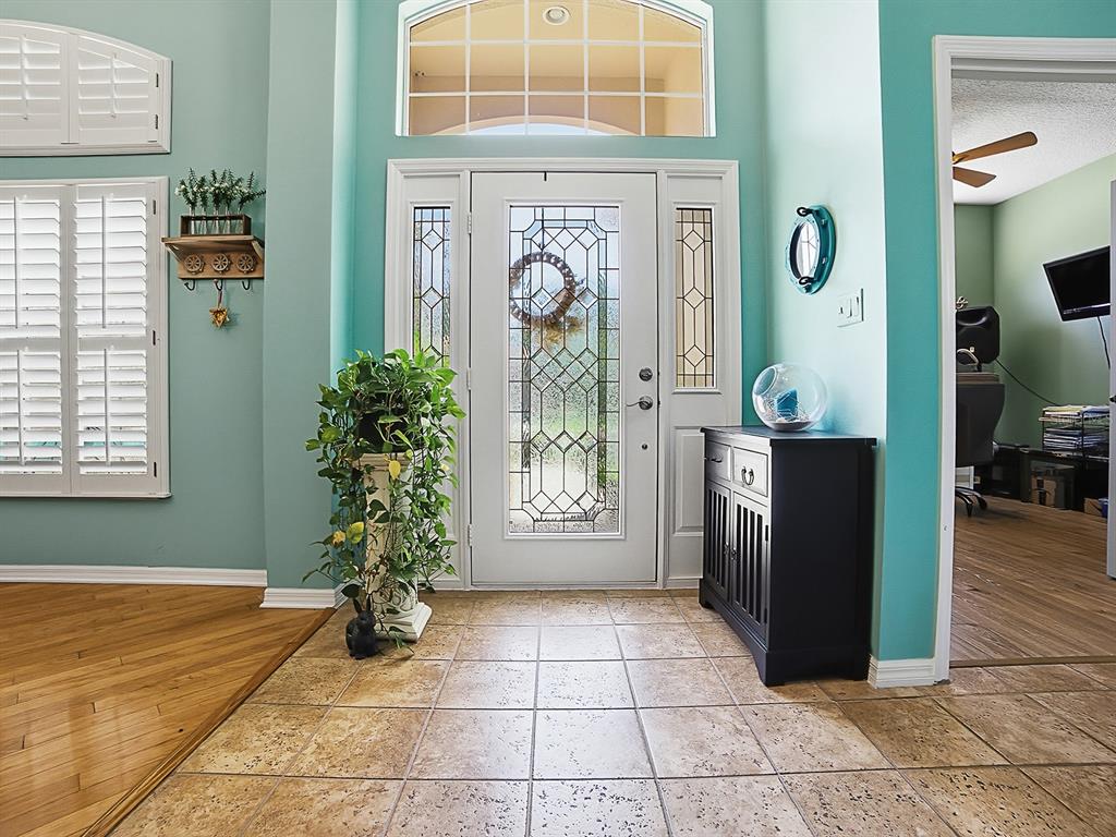 An entryway features a white front door with sidelights, tile flooring, and teal-colored walls — 24511 BOCAGE WAY, LEESBURG, FL